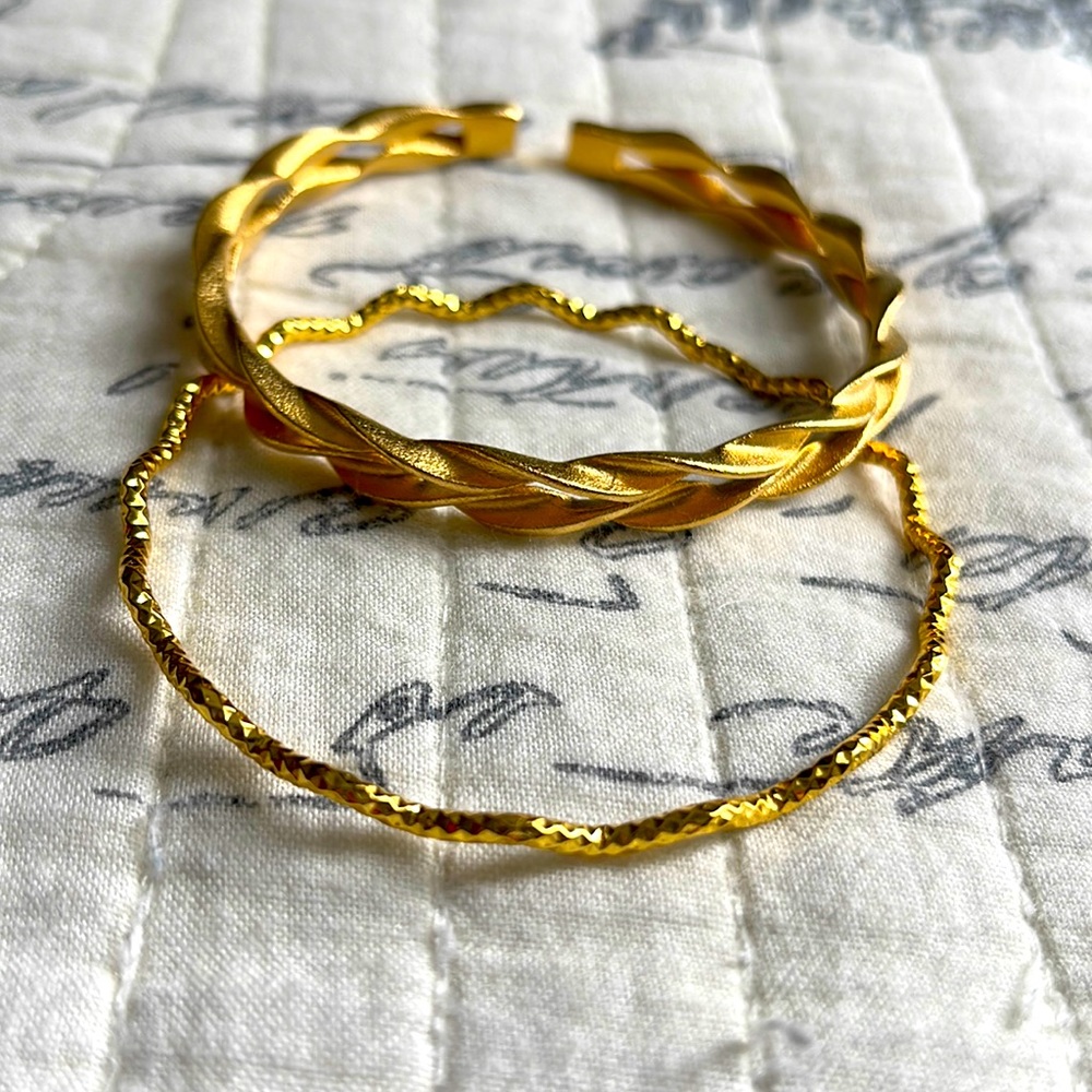 Two intricate 999 gold finished bracelets.